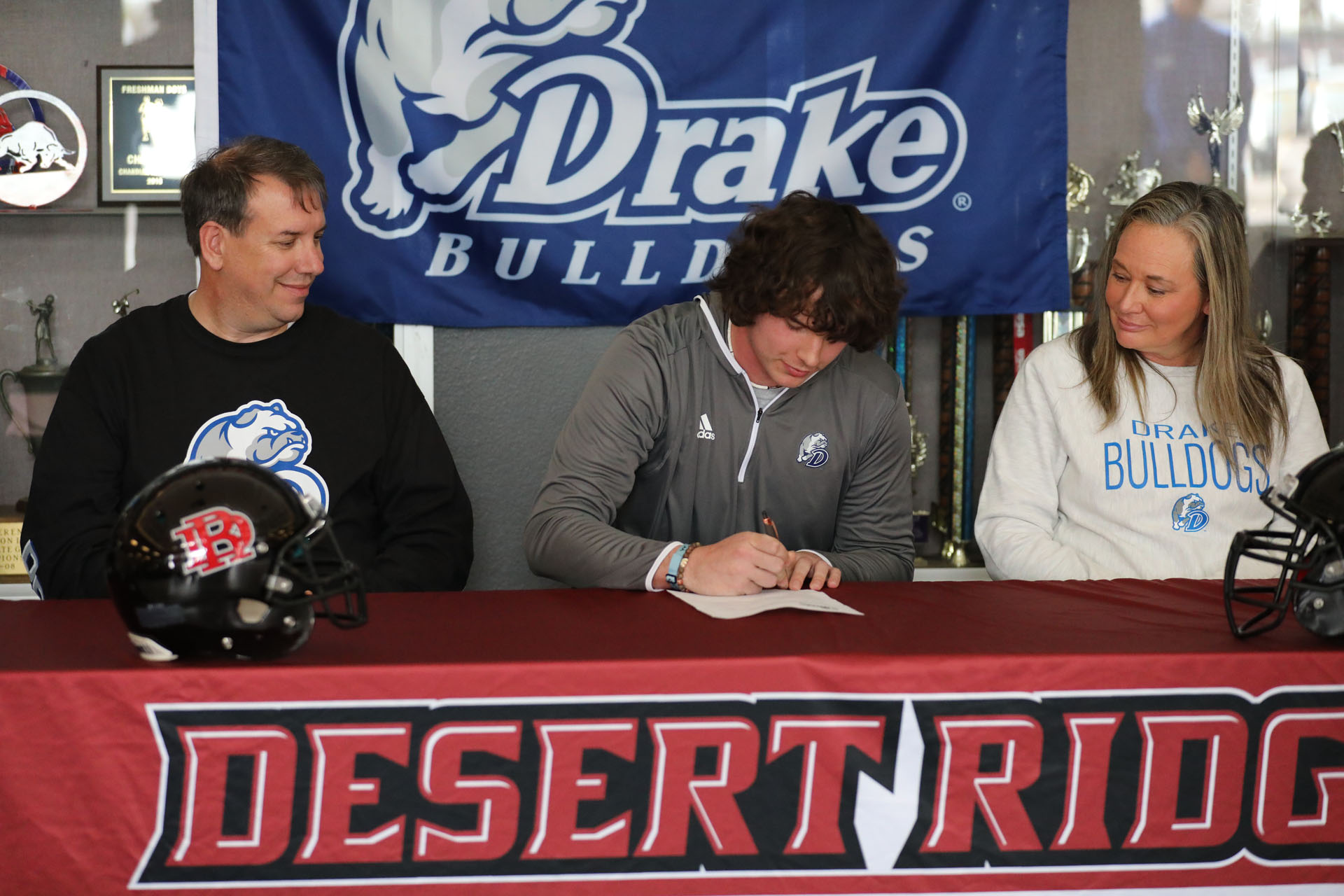Parents watch as Jacob signs with Drake Football